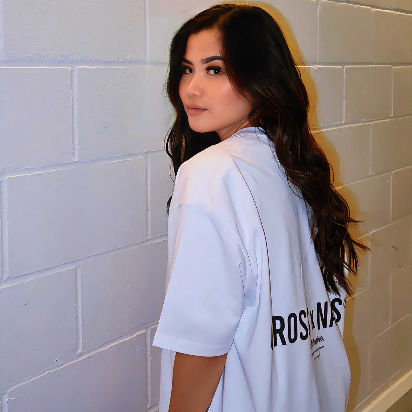 Crossxnails® Oversize Tee in Lucent White, worn by a model showcasing the back logo design against a neutral background.