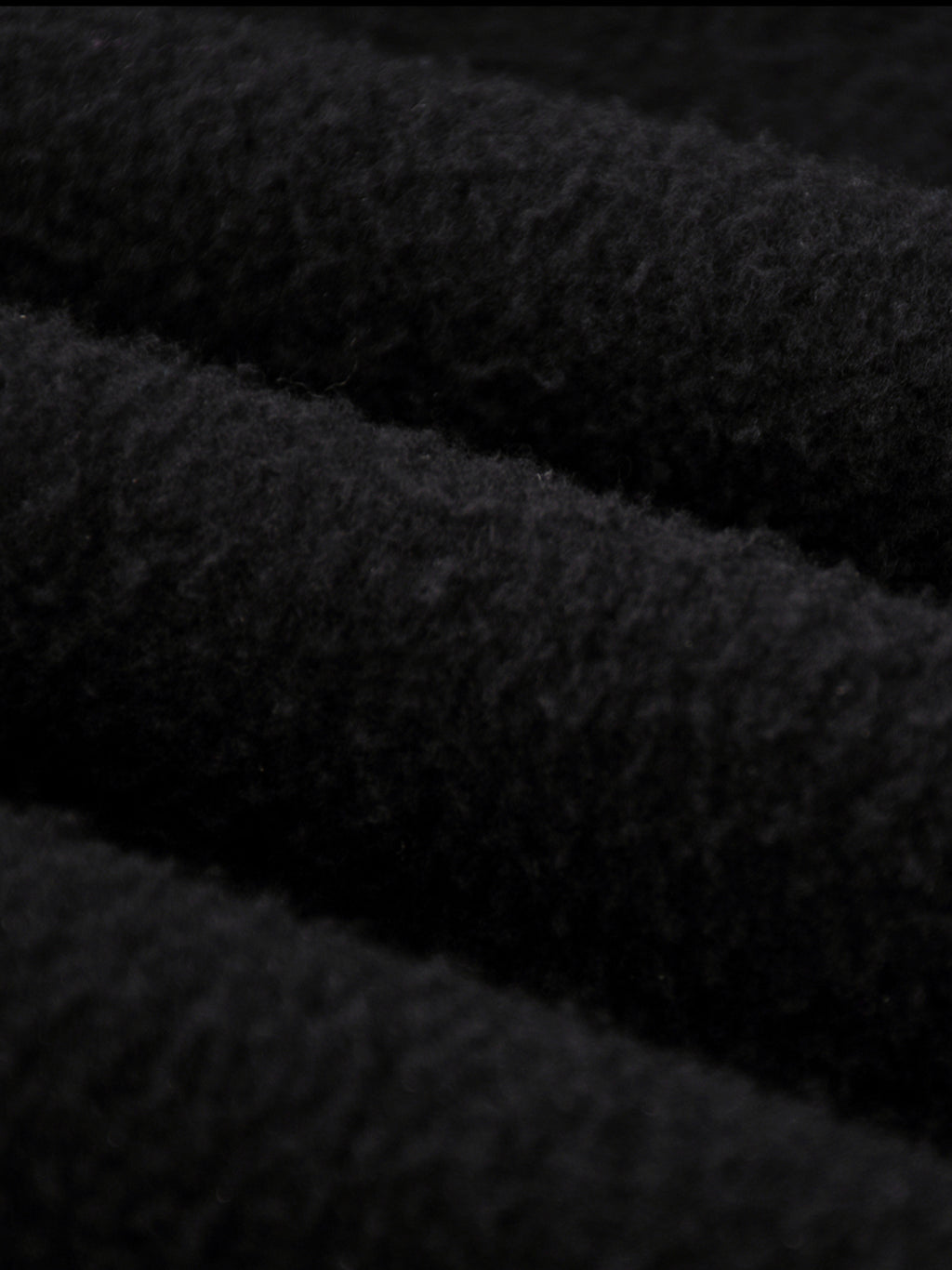 Close-up of thick black fleece fabric for Crossxnails Fleeced Jogger Pants, showcasing premium texture for comfort and warmth.
