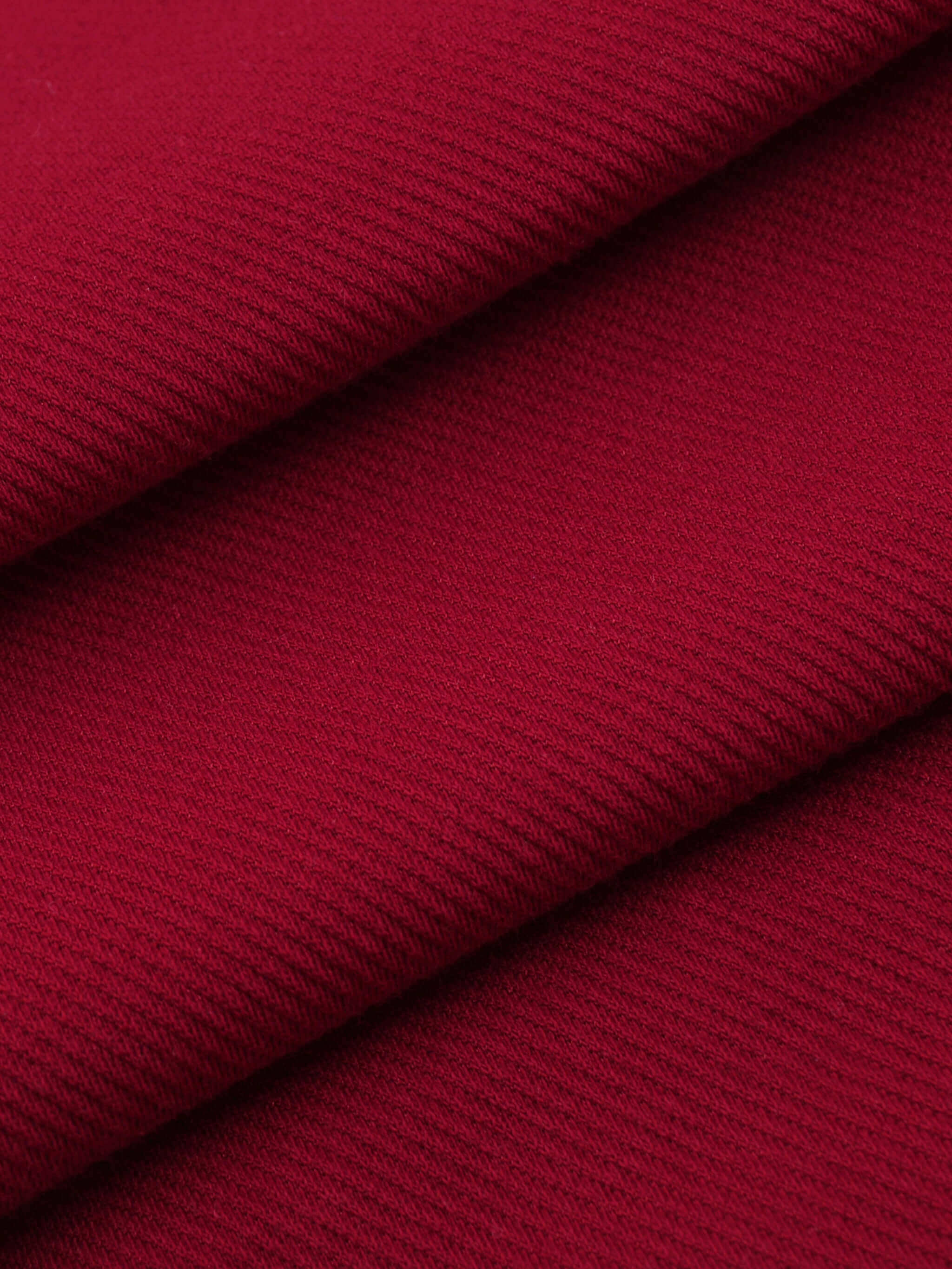 Close-up of soft, textured red fabric showcasing cotton blend ideal for Crossxnails WearGood button-up jersey.